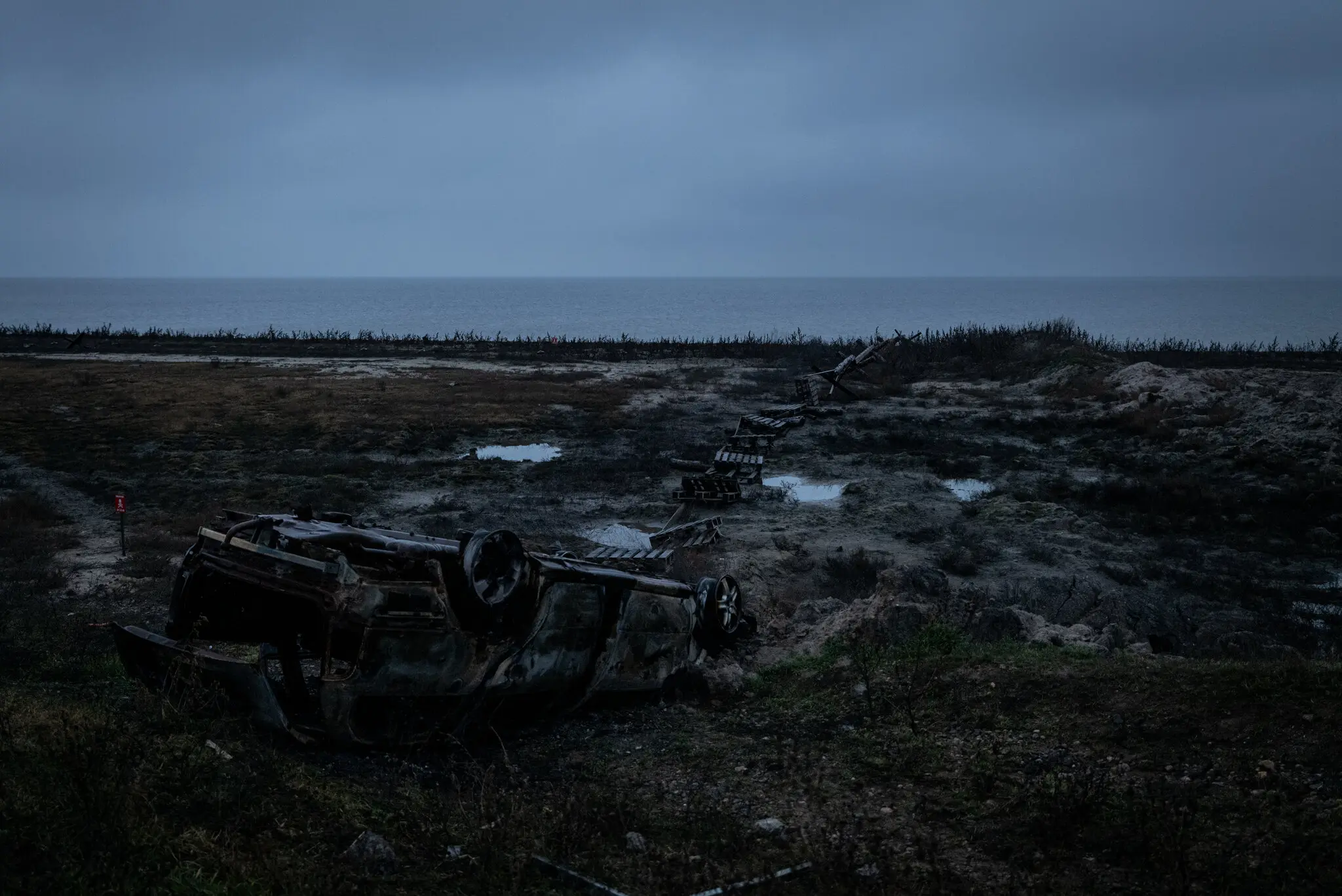 Пошкоджені транспортні засоби та перешкоди на березі Дніпра у січні